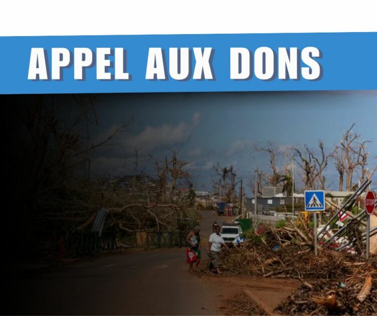 Une photo de Mayotte après le passage de Chido. Des débris jonchent le sol et les bâtiments sont détruit. Un bandeau bleu affiche le titre suivant "Appel aux dons"